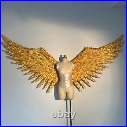 Large performance props show golden feather angel wings