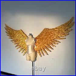 Large performance props show golden feather angel wings