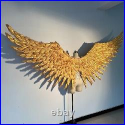 Large performance props show golden feather angel wings