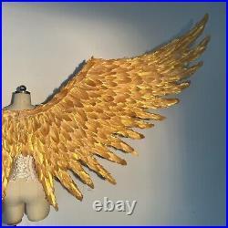 Large performance props show golden feather angel wings