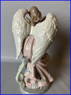 Mark O'Well large angel withopalescent wings leaning on trellis holding dove